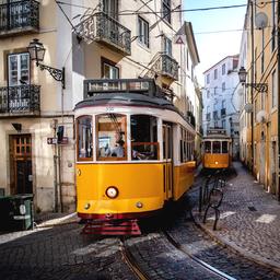 Straßenbahnen fahren durch die engen Straßen des Alfama-Viertels in Lissabon, Portugal.