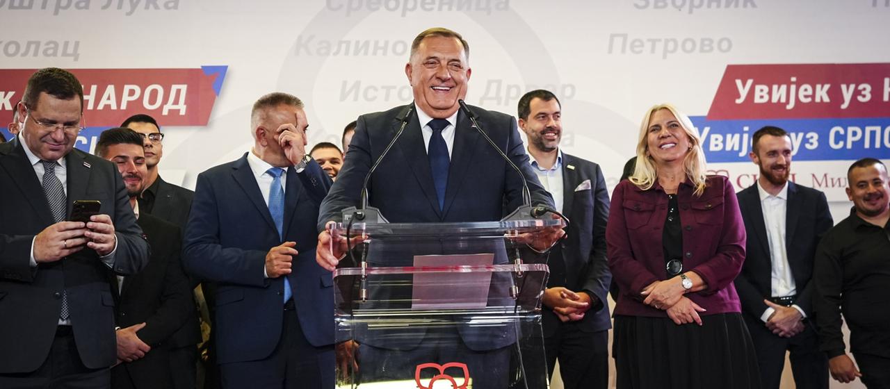 Milorad Dodik steht lachend an einem Rednerpult