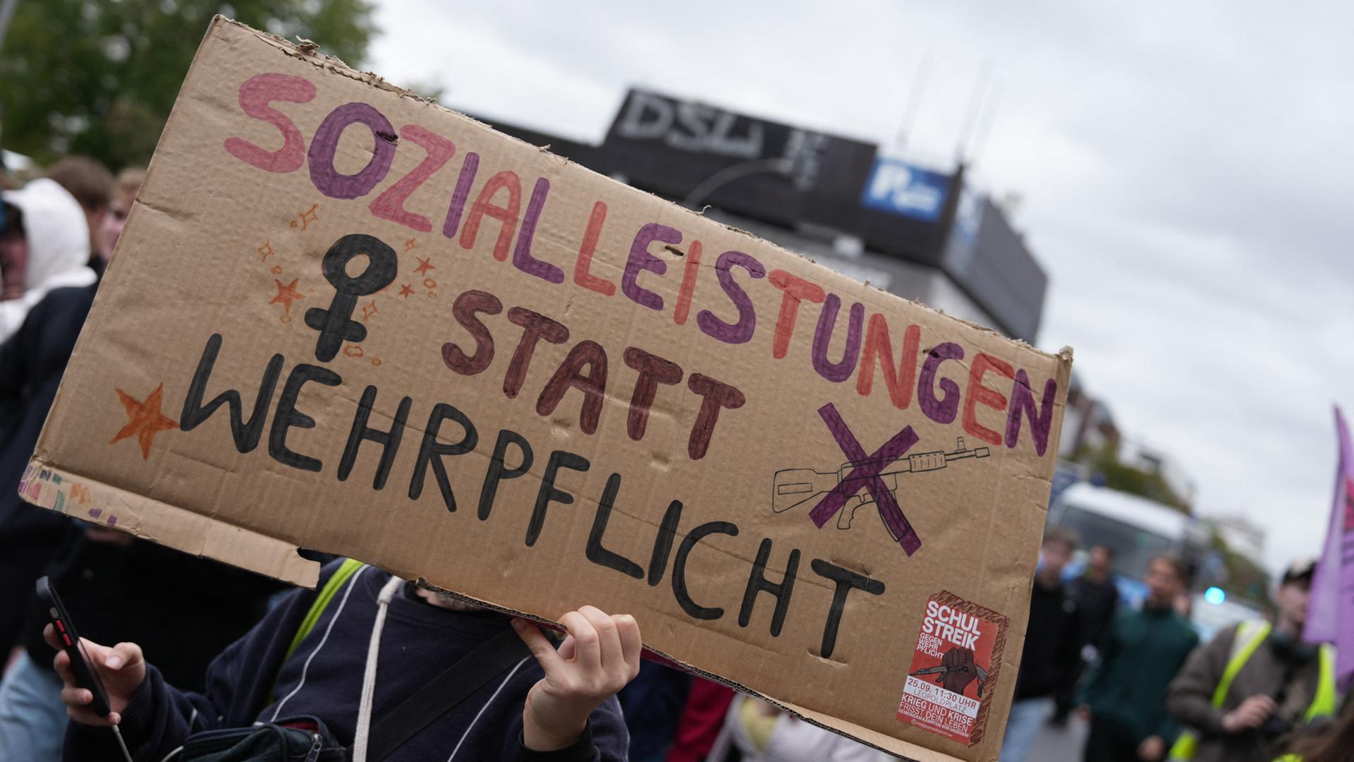 Menschen demonstrieren mit einem Schild mit der Aufschrift 