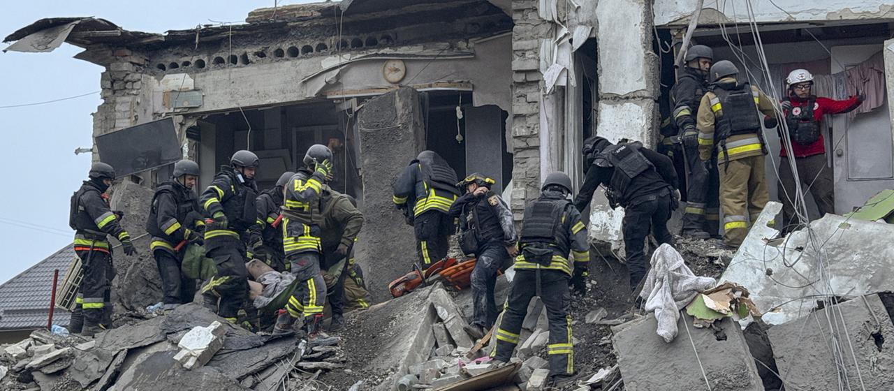 Rettungskräfte durchsuchen ein stark zerstörtes Gebäude in Saporischschja.