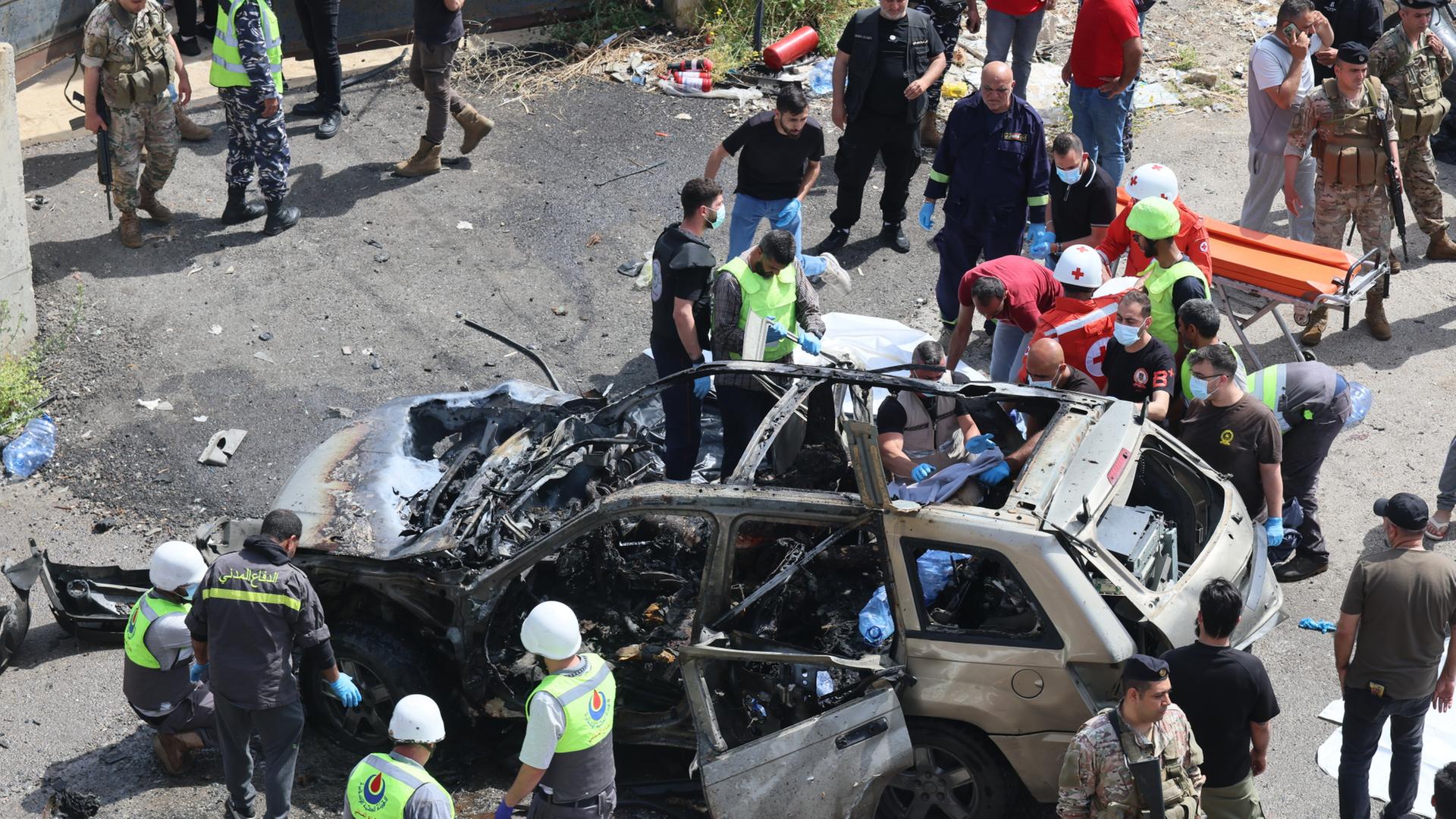 Rettungskräfte untersuchen die Trümmer eines Fahrzeugs in der Stadt Jiyeh südlich von Beirut (Libanon). | EPA