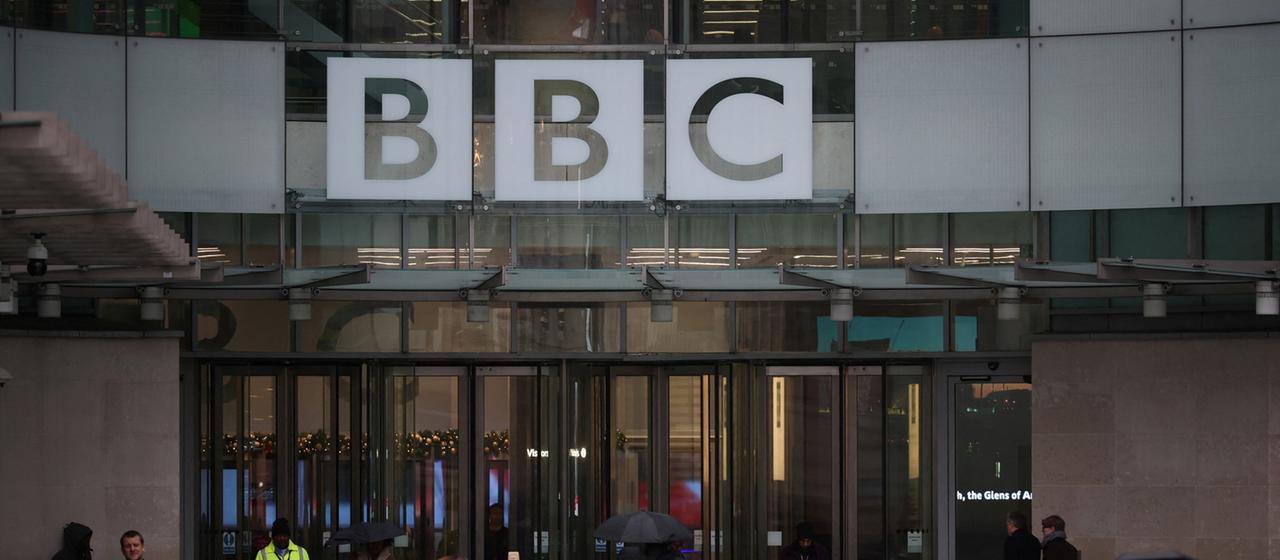 Menschen gehen am BBC Hauptsitz in London vorbei.