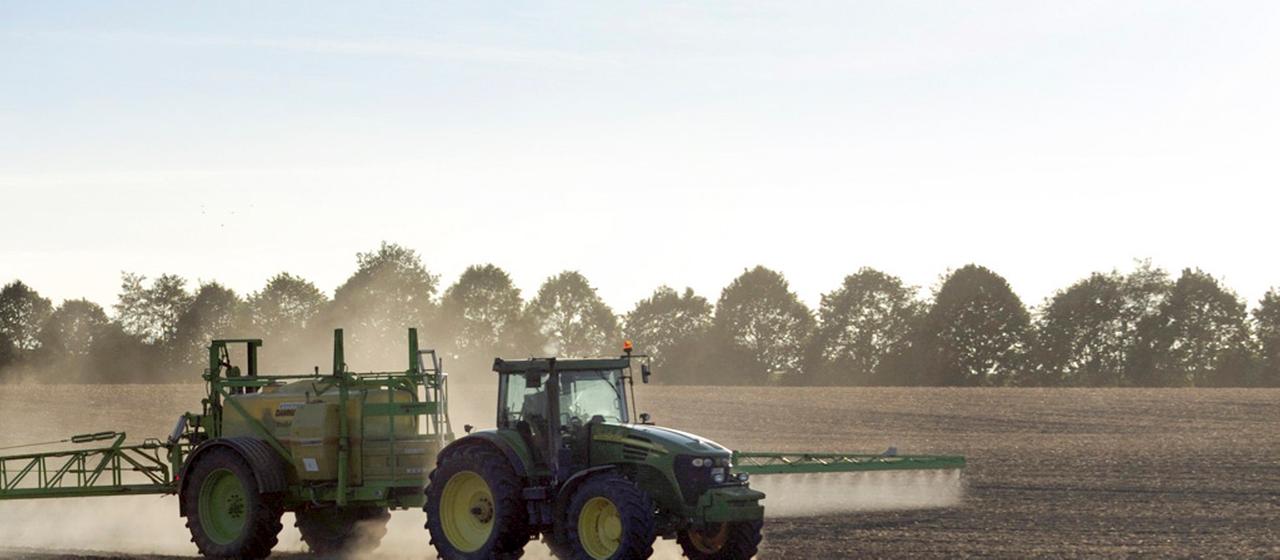 Ein Bauer besprüht sein Feld.