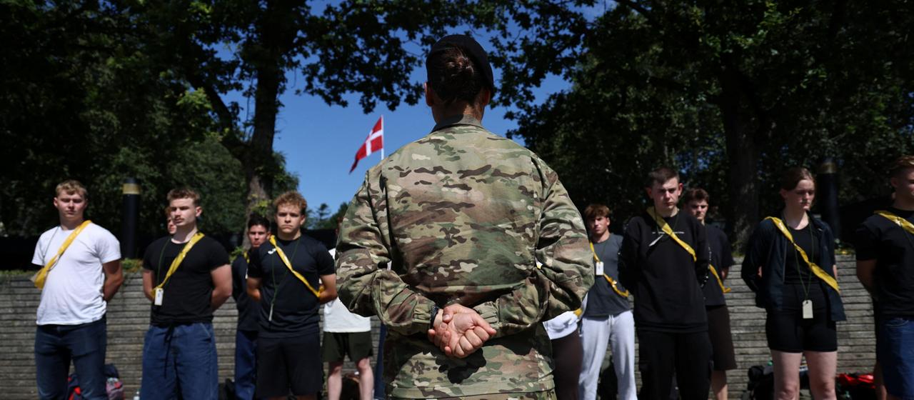 Neue Rekruten stehen vor einem Soldaten in Dänemark