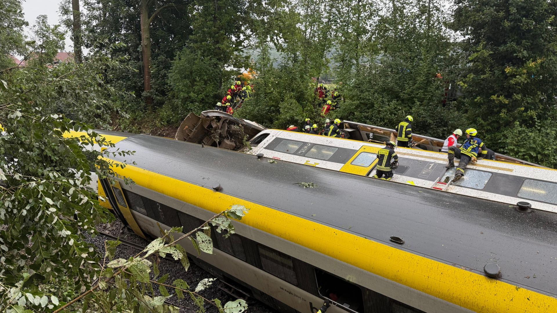 Rettungskräfte suchen in einem entgleisten im baden-württembergischen Kreis Biberach nach Fahrgästen. | dpa