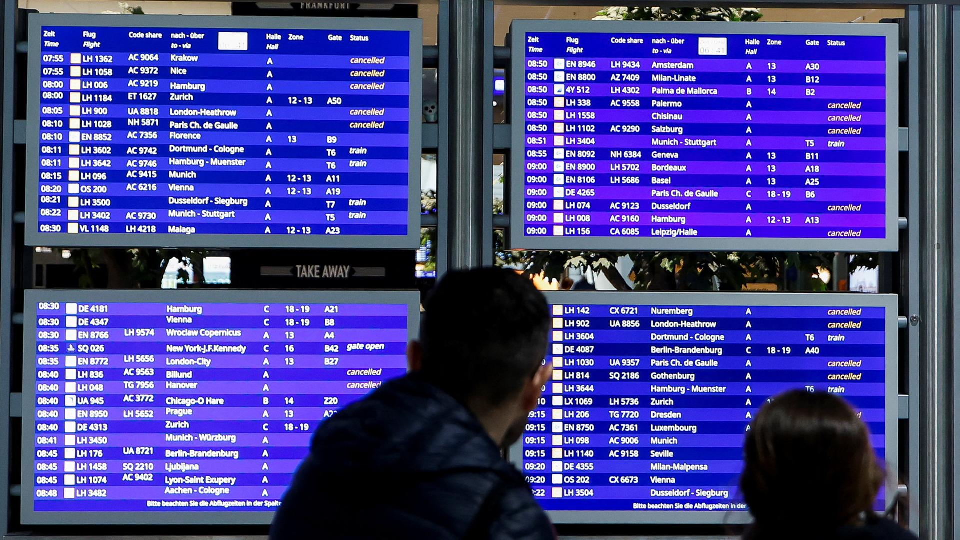 Ein Mann schaut auf eine Anzeigetafel am Frankfurter Flughafen. | REUTERS
