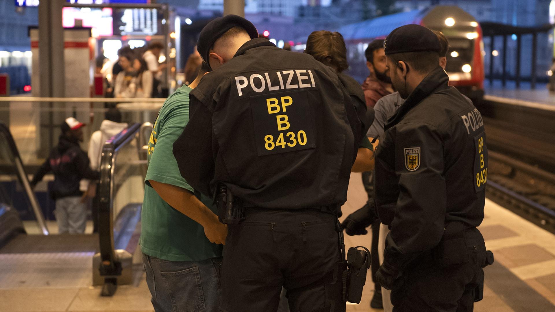 Bundespolizisten überprüfen auf einem Berliner Bahnhof einen Mann. | dpa