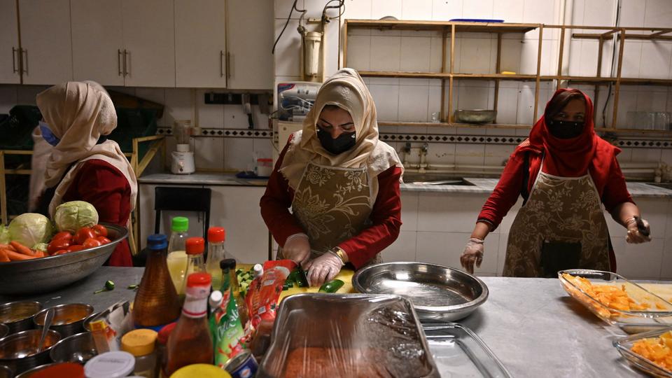 Frauen, die Opfer von häuslicher Gewalt geworden waren, kochen in einem Gebäude in Kabul (Afghanistan), das ein Frauenhaus und ein Restaurant ist.
