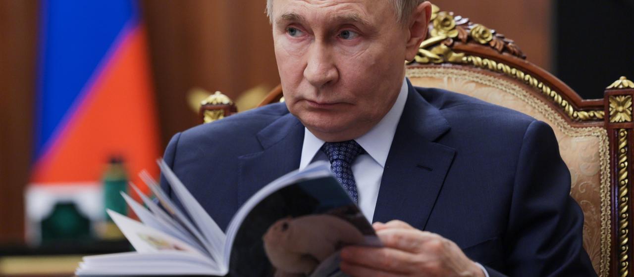 Wladimir Putin blättert in einem Magazin. | dpa Wladimir Putin blättert in einem Magazin.