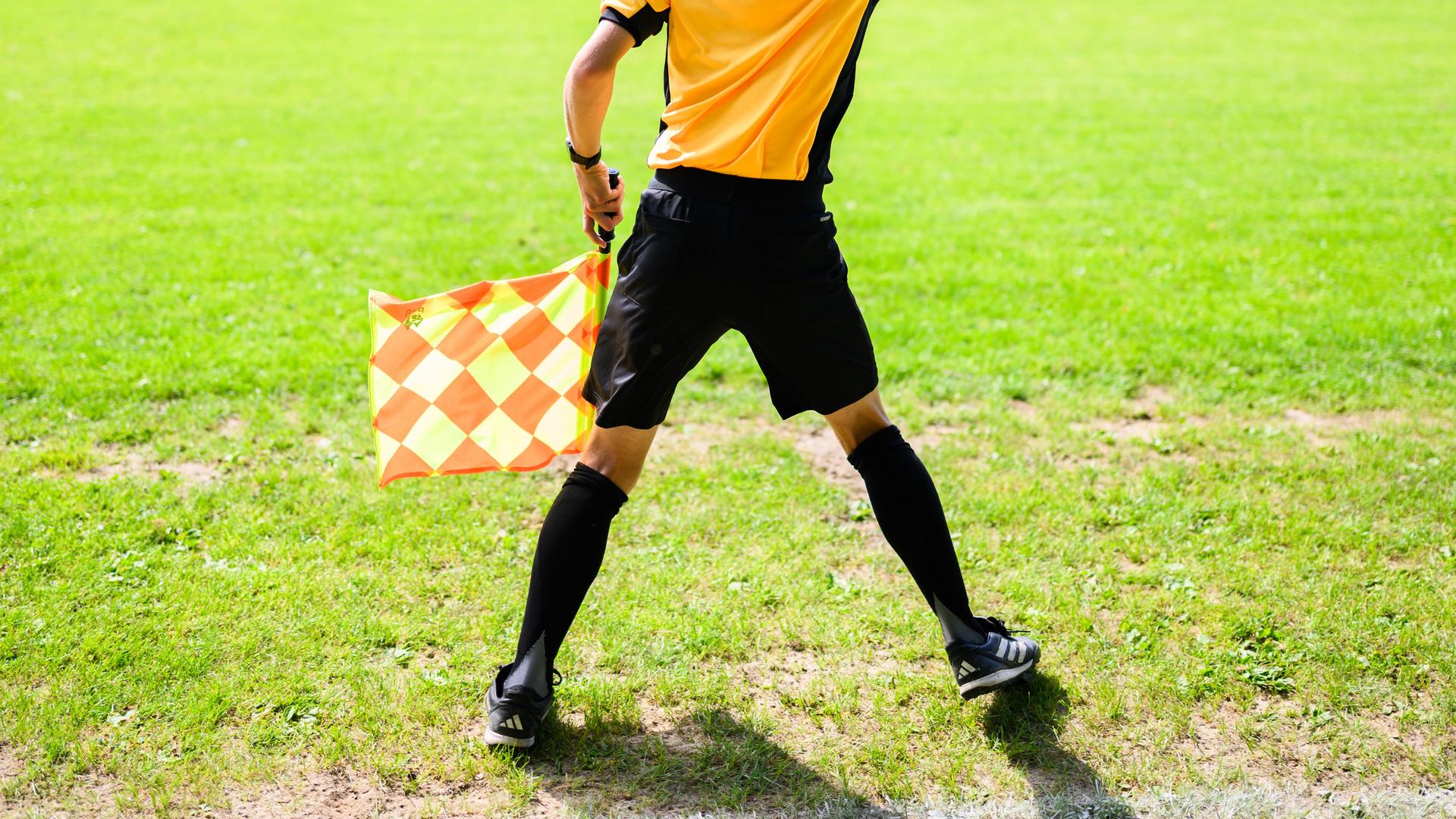Ein Linienrichter auf einem AmateurfuÃballplatz, der Rasen ist beschÃ¤digt. | dpa /Julian Stratenschulte