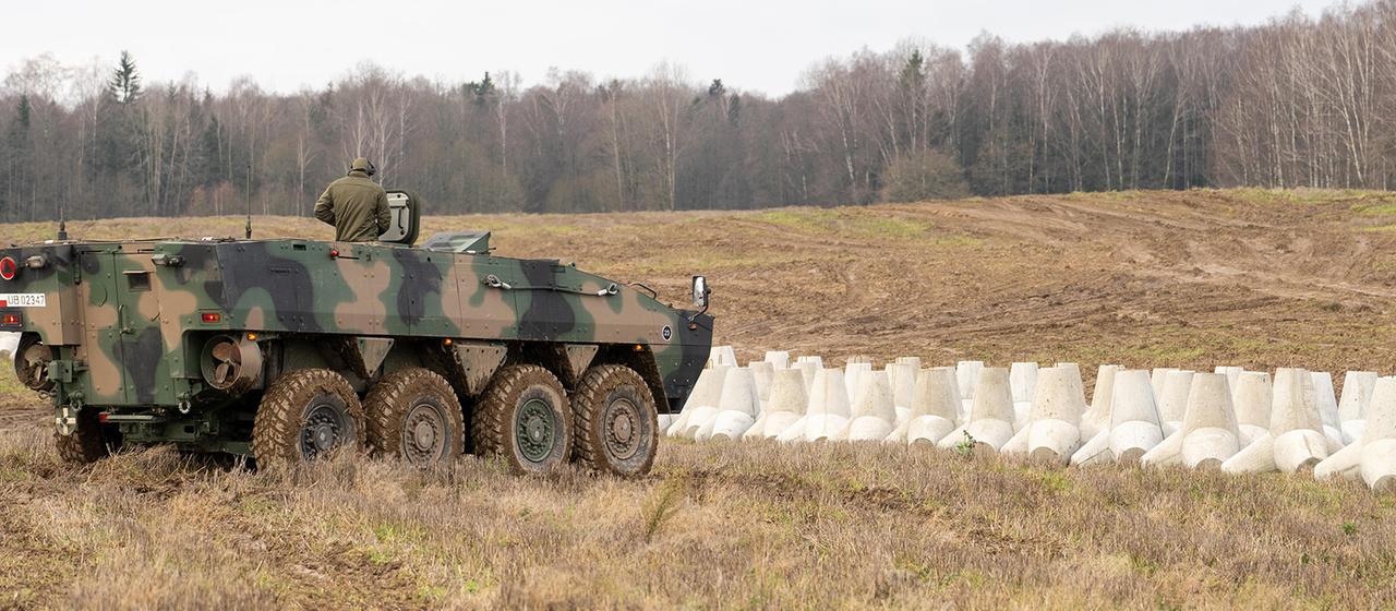 Ein Panzer neben Betonbarrieren an der polnischen Grenze zu Russland in Dabrowka sind.