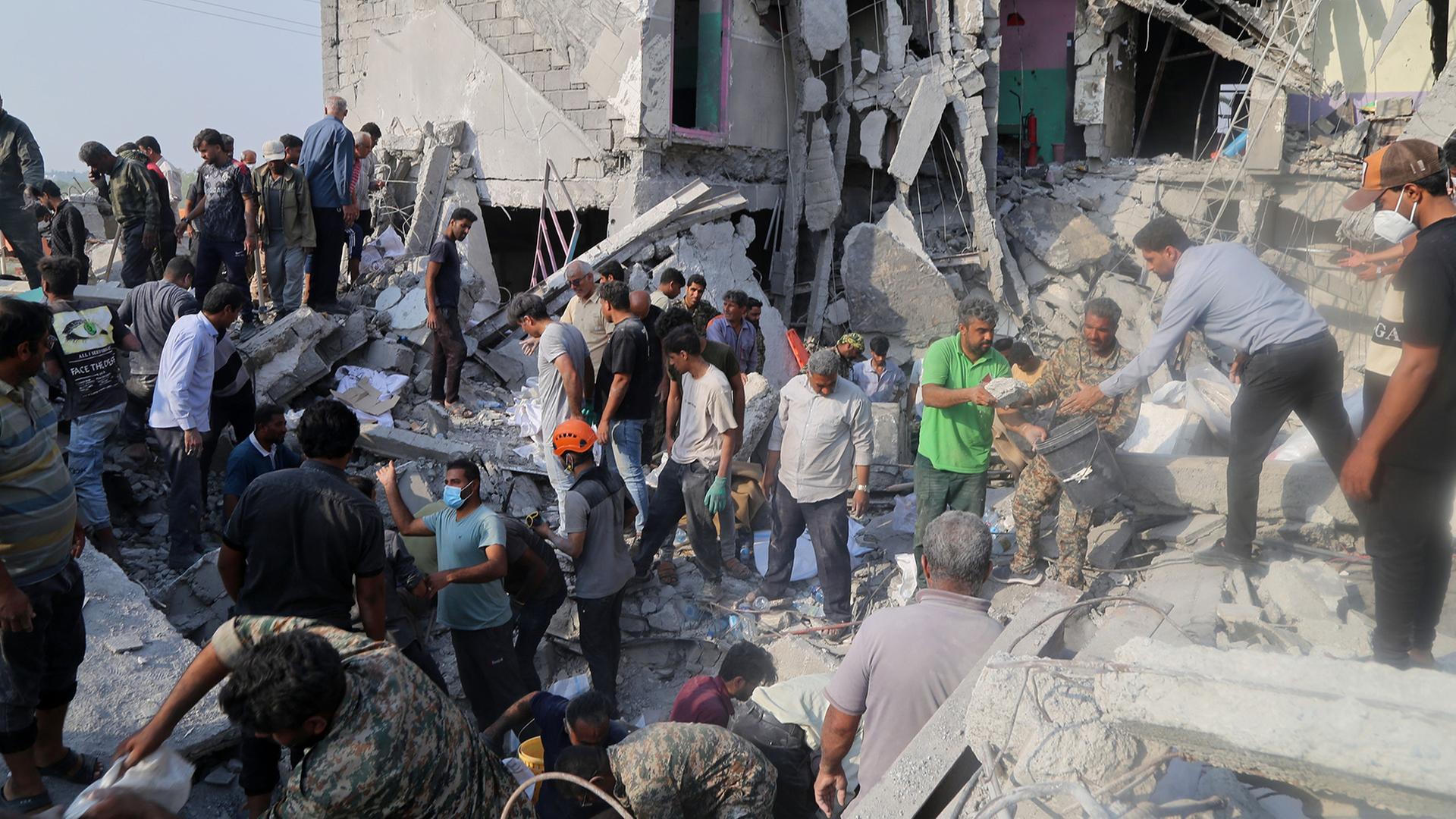 Rettungskräfte und Anwohner durchsuchen die Trümmer einer Schule in Minab. | Uncredited/Mehr News Agency/AP/d