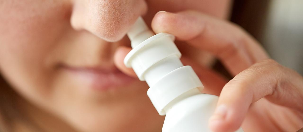 Eine Frau benutzt Nasenspray
