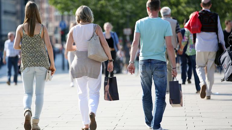 Passanten gehen mit Einkaufstüten durch die Innenstadt in Hamburg.