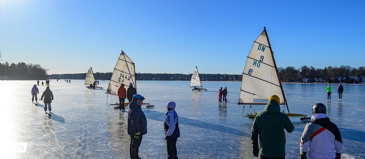 Eissegler und viele Personen stehen auf dem zugefrorenen Großen Müllroser See. (Quelle: dpa/Patrick Pleul)