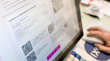 Auf einem Bildschirm in einer Apotheke sind Hinweise zu E-Rezepten angezeigt.