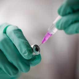 Eine Spritze mit einem Impfstoff wird aufgezogen