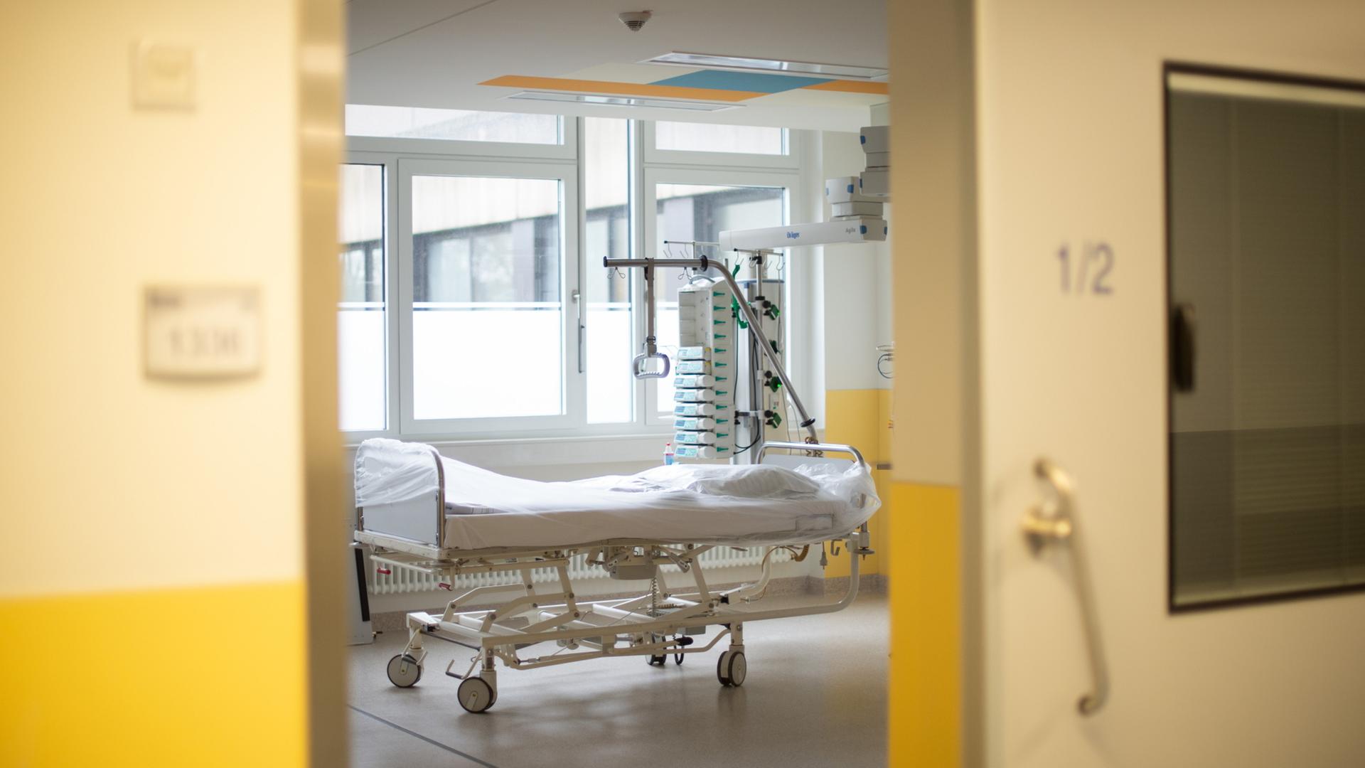 Leeres Bett hinter einer Tür einer Intensivstation (Archiv) | dpa