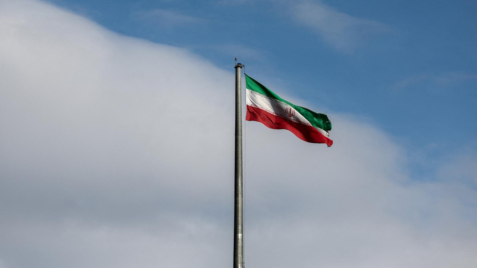Eine iranische Flagge weht an einem Mast. | via REUTERS