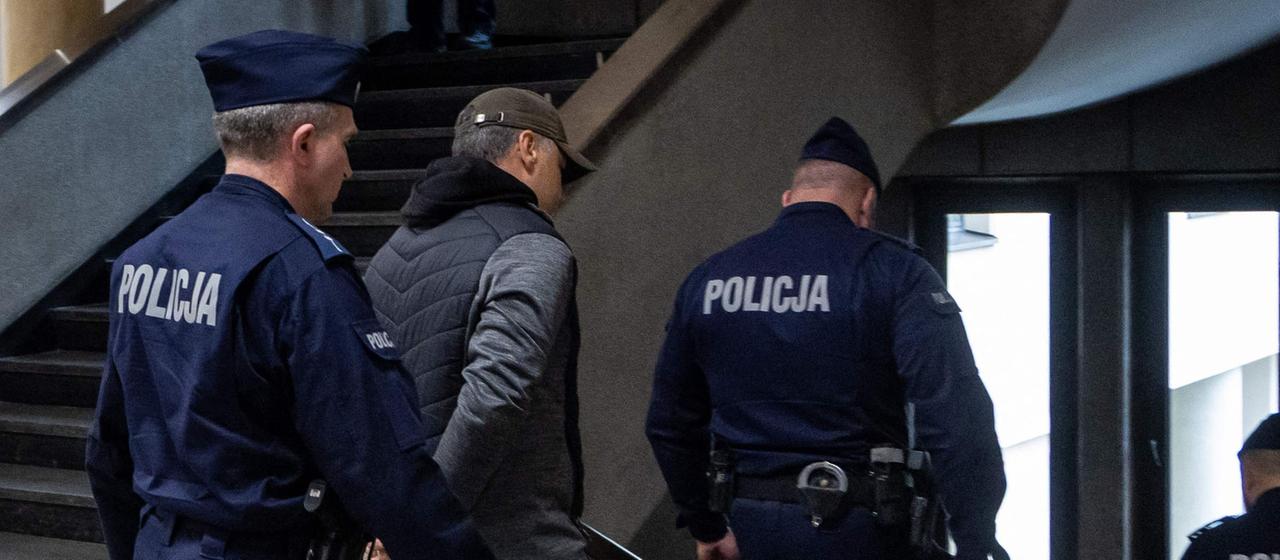 Polizeibeamte eskortieren den Ukrainer Z nach einer Anhörung aus dem Gerichtssaal des Regionalgerichts in Warschau, Polen. | AFP Polizeibeamte eskortieren den Ukrainer Z nach einer Anhörung aus dem Gerichtssaal des Regionalgerichts in Warschau, Polen.