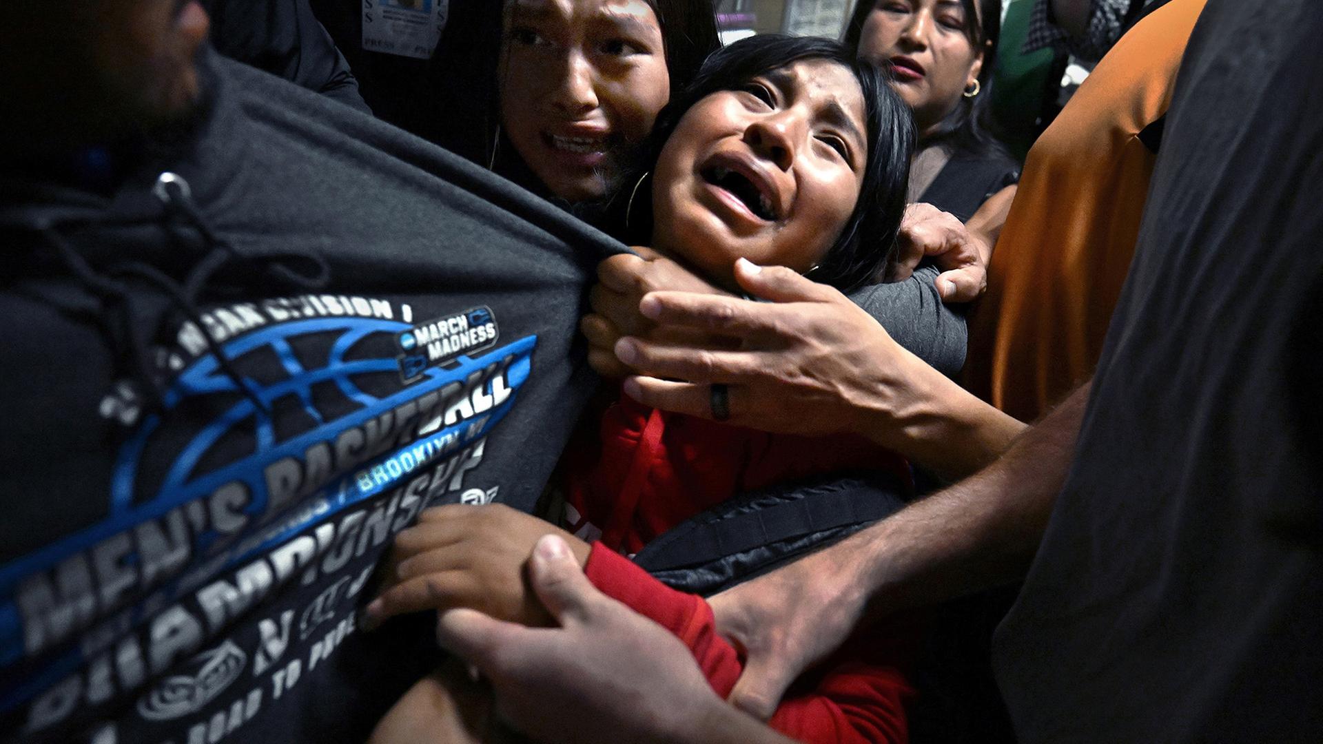 Menschen sind dicht gedrÃ¤ngt, HÃ¤nde zerren mit verzweifelten Gesichtern an einem grauen Sweatshirt. | EPA