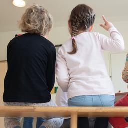 Kinder sitzen auf einer Bank