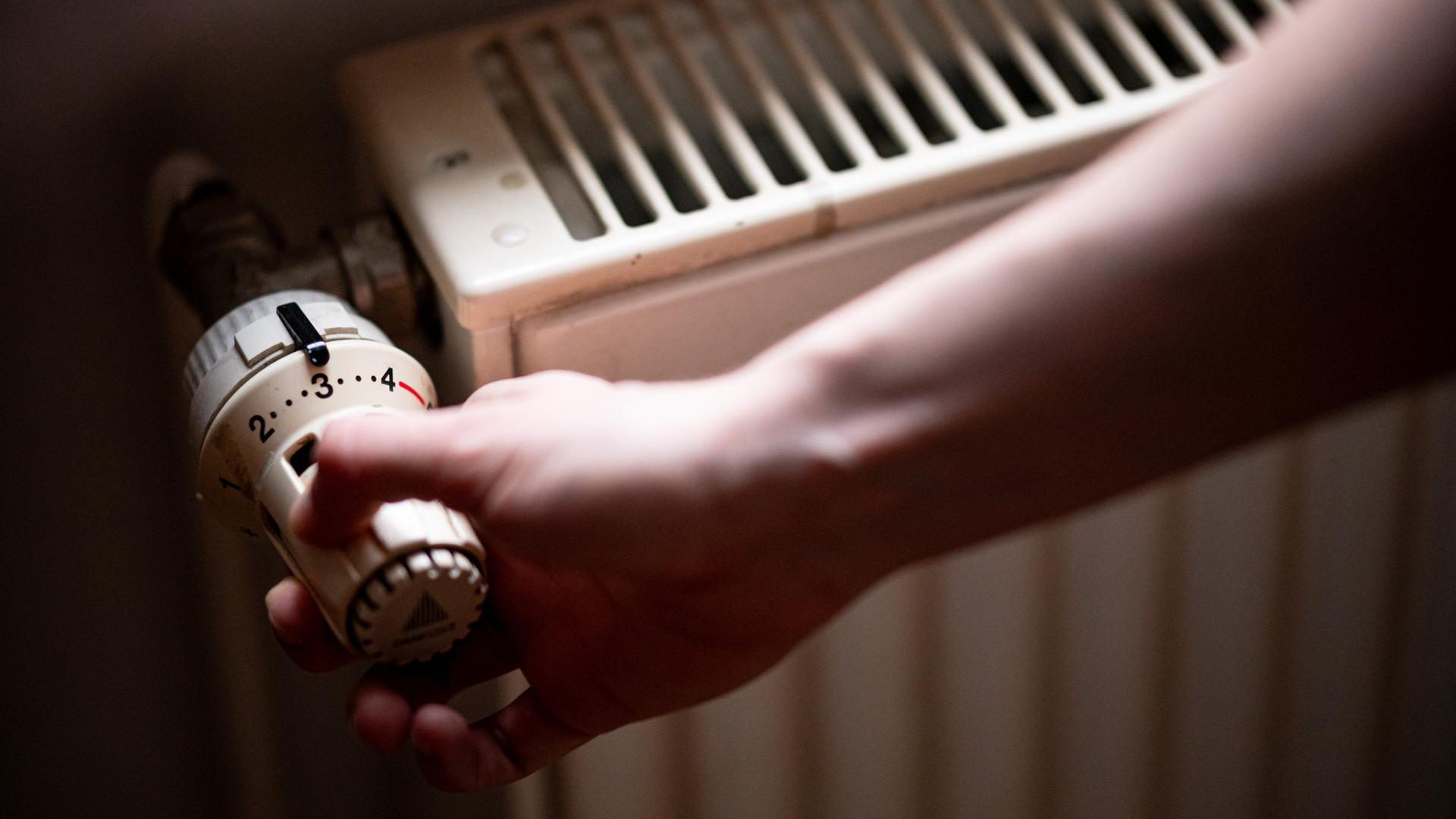 Eine Person benutzt einen Heizkörper. | dpa