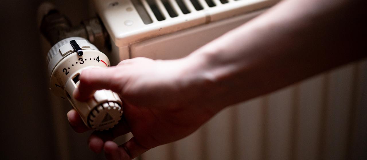 Eine Person benutzt einen Heizkörper.