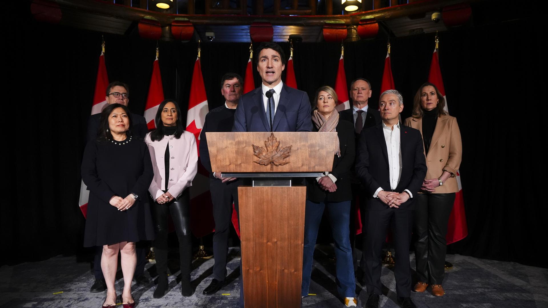 Justin Trudeau steht mit Mitgliedern des kanadischen Kabinetts und Kanadas Botschafterin in den USA