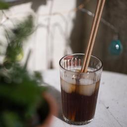 Strohhalme aus Papier stecken in einem Glas mit Limonade.