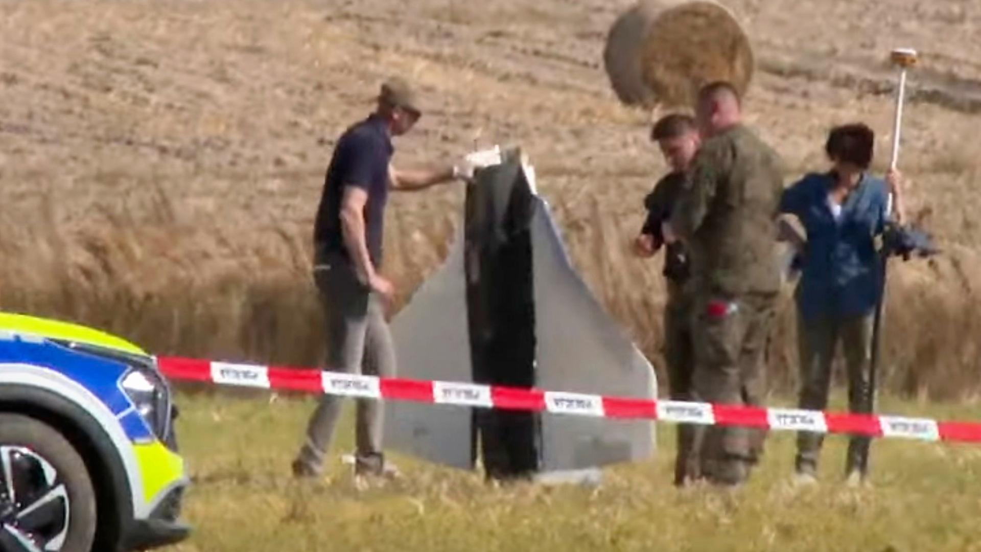 Einsatzkräfte sichern Teile einer Drohne, die von Polen abgeschossen wurde. | dpa