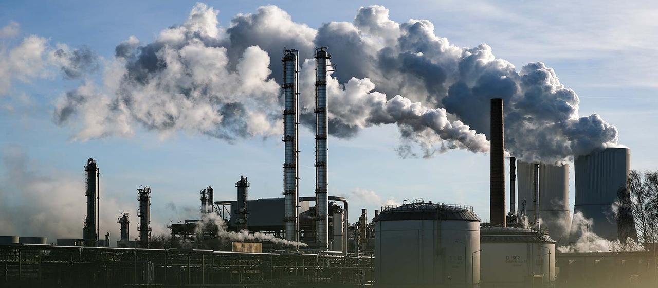 Rauchende Schornsteine einer Industrieanlage im Chemiepark Böhlen.