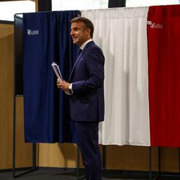 Emmanuel Macron steht vor einer Wahlkabine