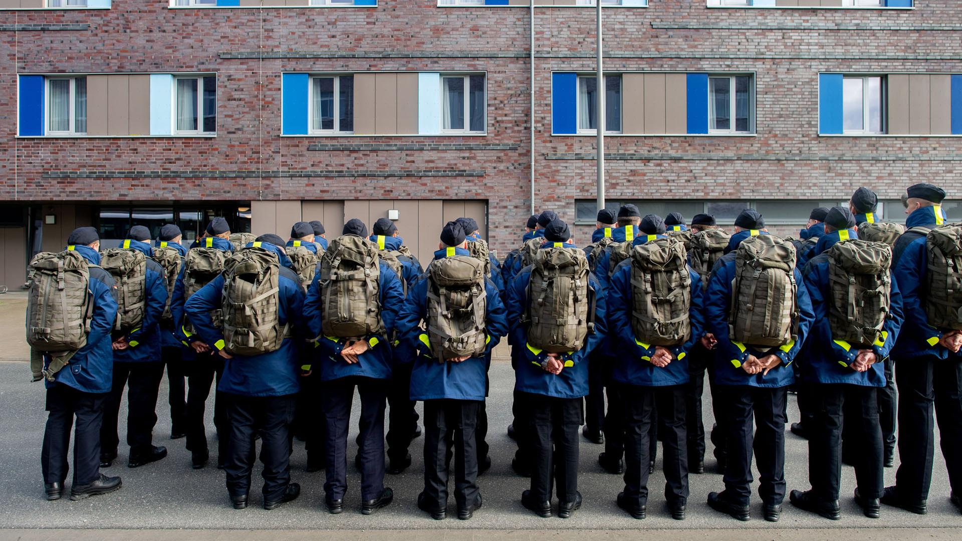 Zahlreiche Rekruten der Marine stehen mit Rucksäcken vor einer Unterkunft im Marinestützpunkt Wilhelmshaven, Niedersachsen. | dpa