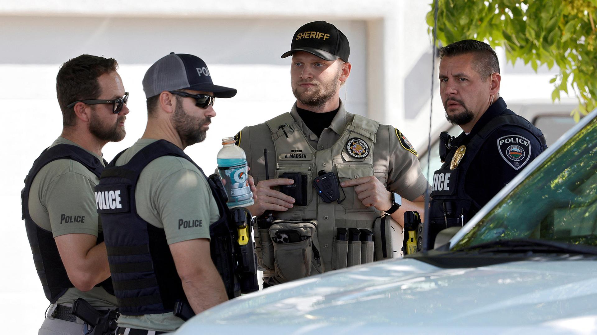 US-Polizisten reden miteinander vor einem Fahrzeug. | REUTERS