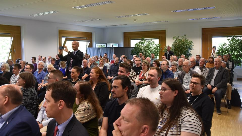 Der Konferenzraum in der Chemnitzer Filiale der Bundesbank war am Mittwoch bis auf den letzten Platz gefüllt. | MDR/Thomas Friedrich In einem Raum schauen sitzende Zuschauer in Richtung Auditorium.