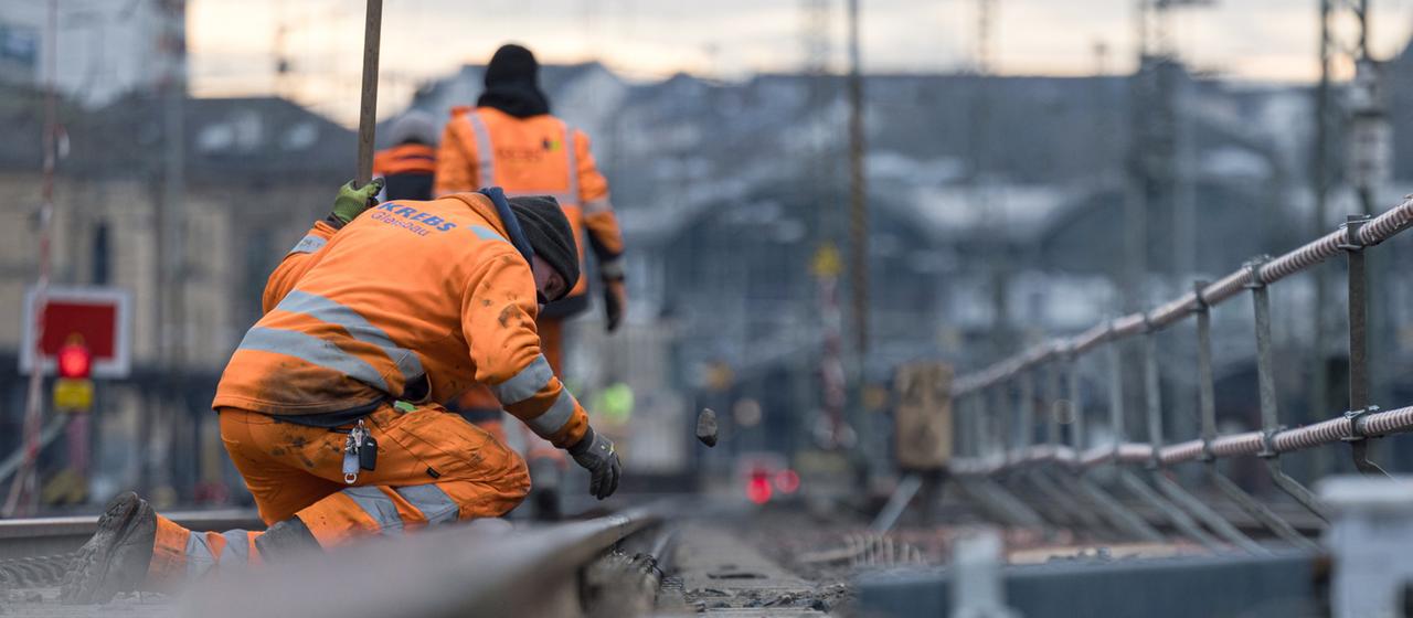 Bauarbeiter arbeiten an Gleisen am Mainzer Hauptbahnhof.