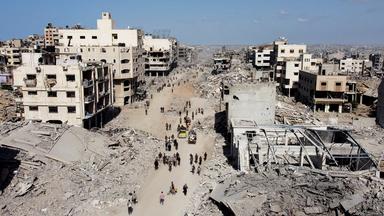 Eine Drohnenaufnahme zeigt Palästinenser, die in Gaza-Stadt an den Trümmern vorbeigehen.