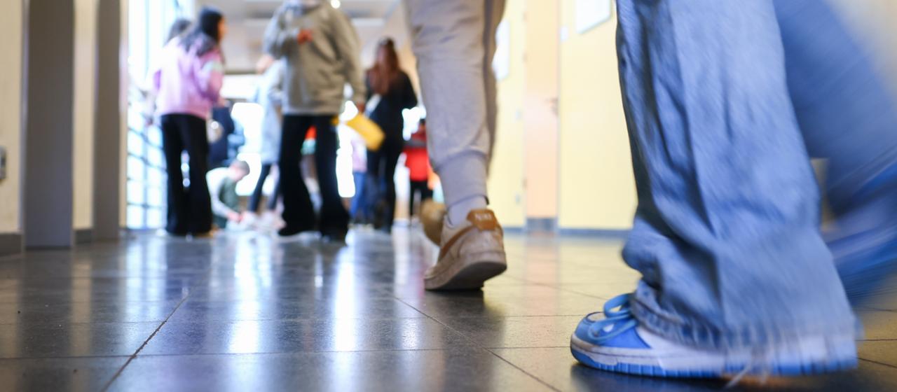 Schüler gehen durch einen Gang zu ihrem Klassenzimmer.