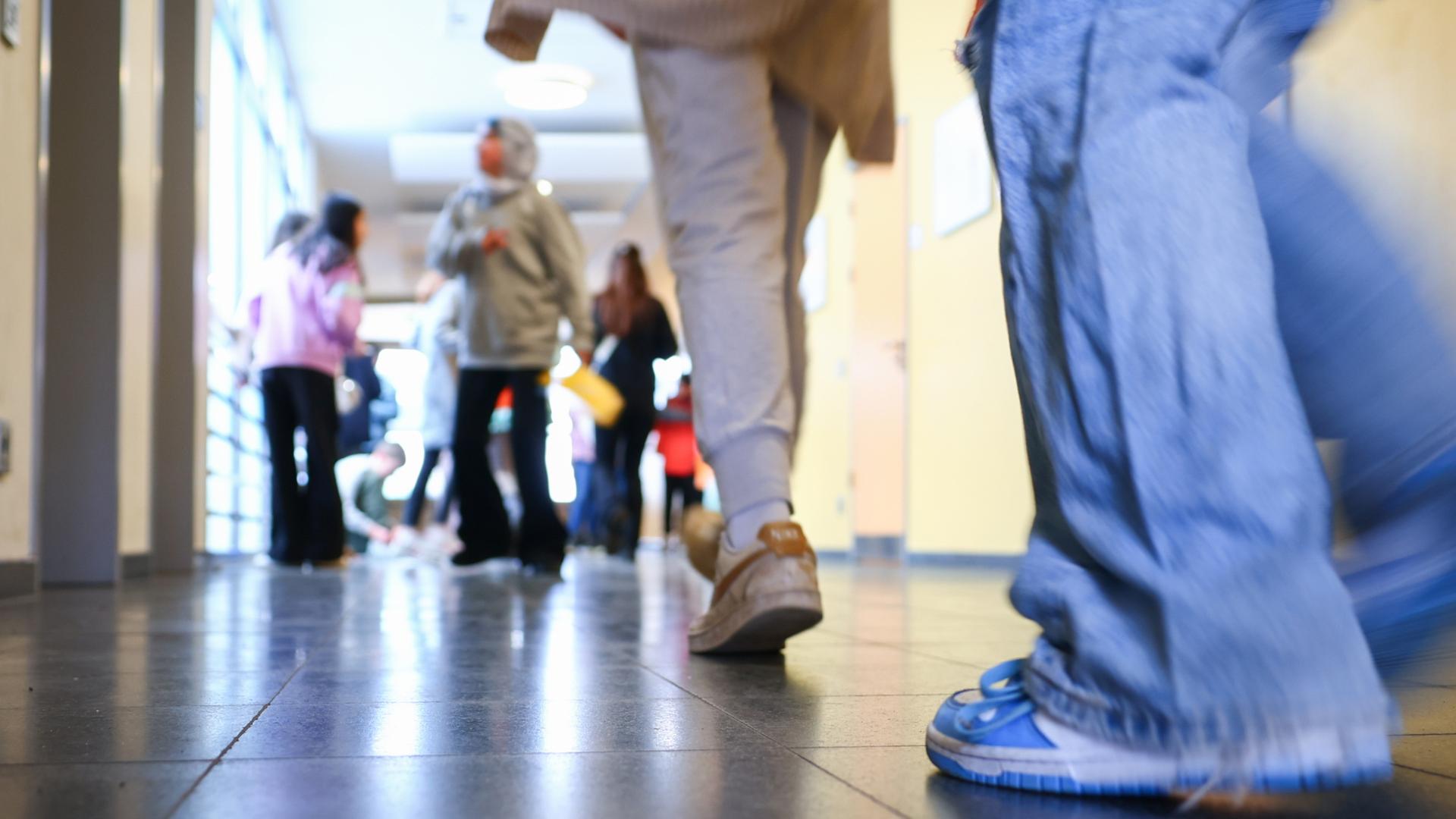 Schüler gehen durch einen Gang zu ihrem Klassenzimmer. | dpa