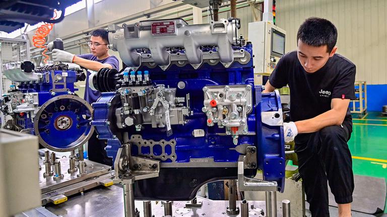 Arbeiter bei der Montage eines Motors in einer Motorenfabrik in Qingzhou (China).