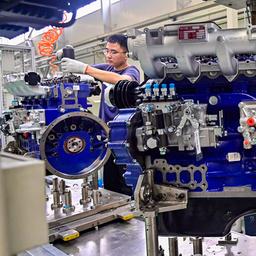 Arbeiter bei der Montage eines Motors in einer Motorenfabrik in Qingzhou (China).