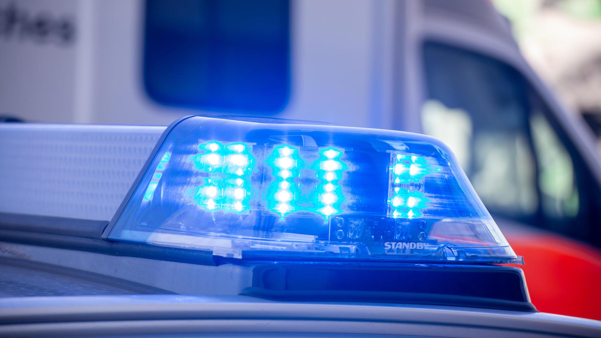 Nahaufnahme von blinkendem Blaulicht bei einem Polizeieinsatz mit Rettungswagen im Hintergrund | picture alliance / Udo Herrmann