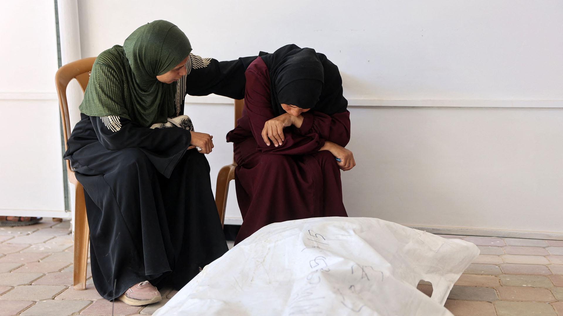 Angehörige sitzen neben einem Leichensack im Nasser-Krankenhauses in Chan Junis im südlichen Gazastreifen. | AFP