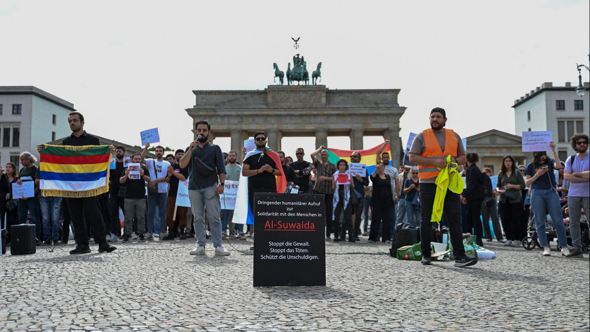 Berlin: Menschen demonstrieren vor dem Brandenburger Tor für den Schutz von Minderheiten in Syrien. | dpa