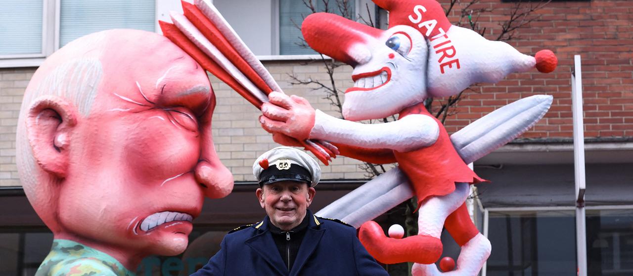 Jacques Tilly posiert vor einem Karnevalswagen, der den russischen Präsidenten Wladimir Putin darstellt.