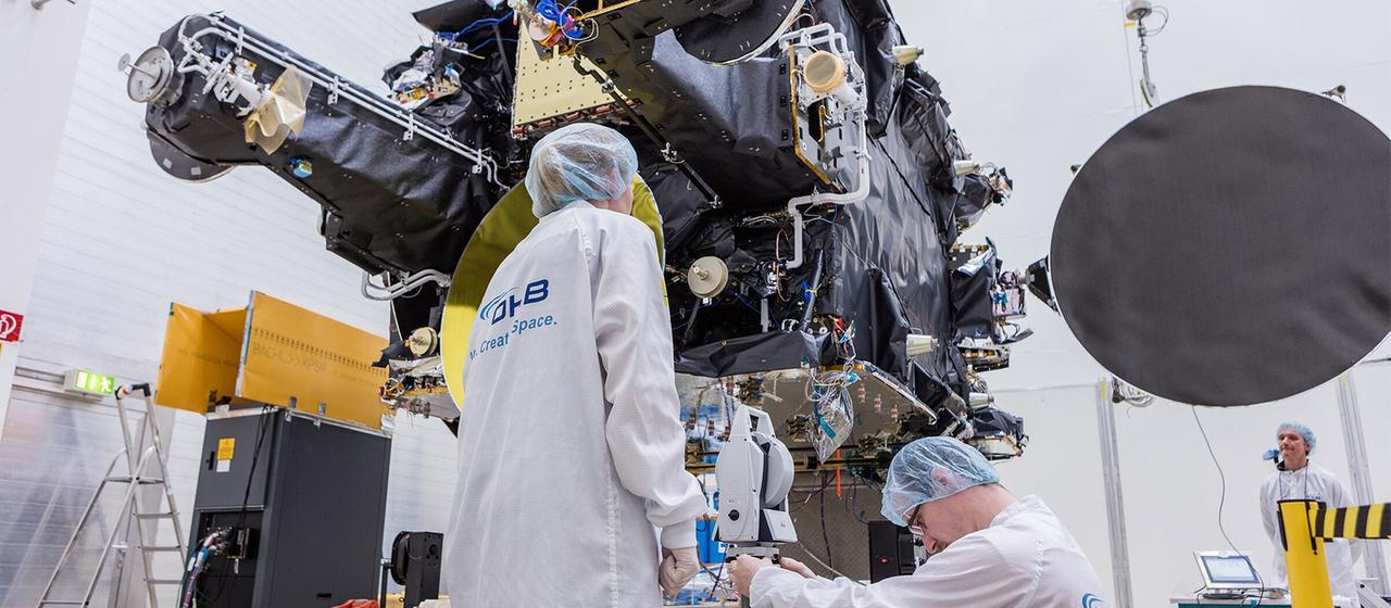 OHB Mitarbeiter prüfen einen Telekommunikationssatelliten (Archivbild).