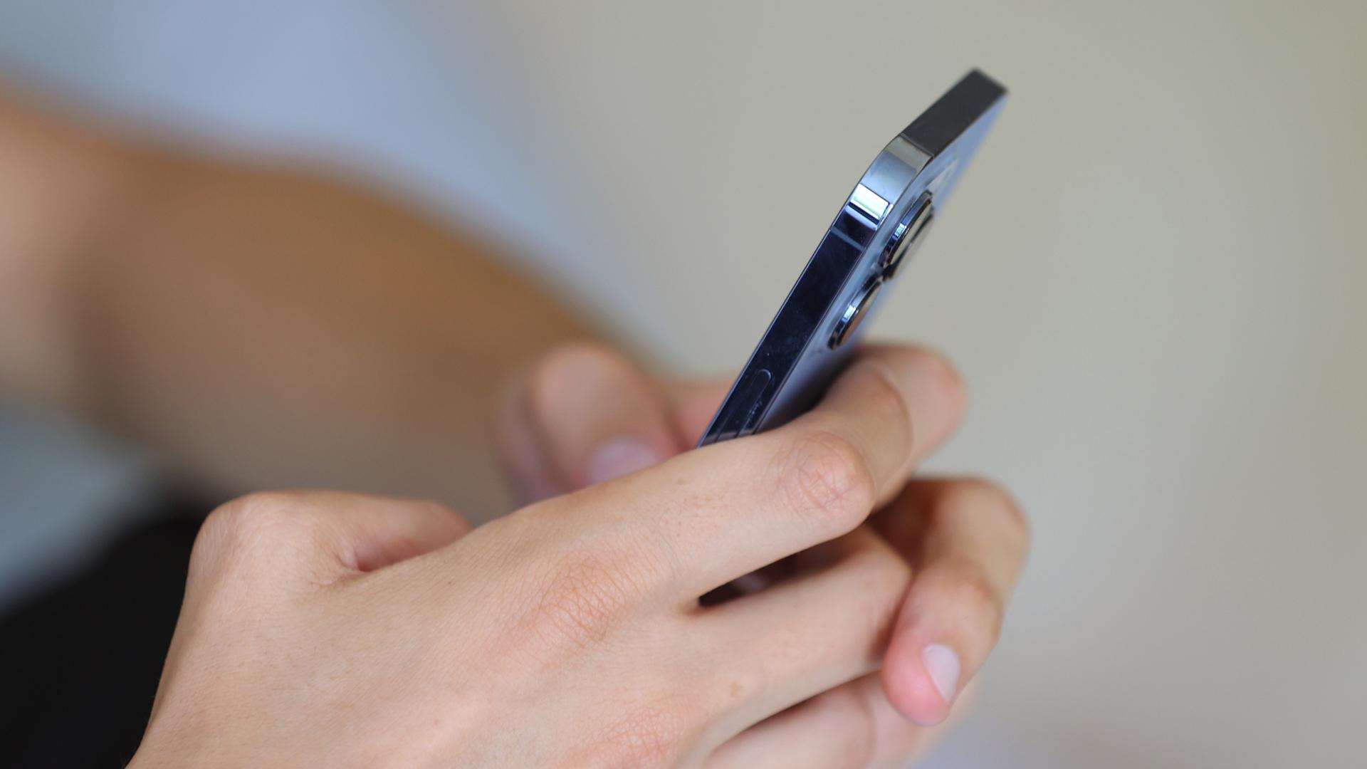 Hnde halten ein Smartphone. | dpa