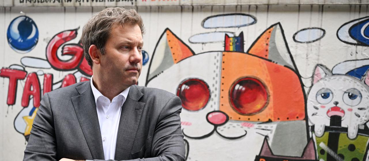 Lars Klingbeil steht vor einem Katzen-Graffiti.