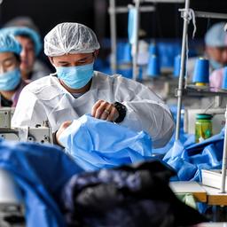 Arbeiter stellen in einer Fabrik in Urumqi Schutzanzüge her